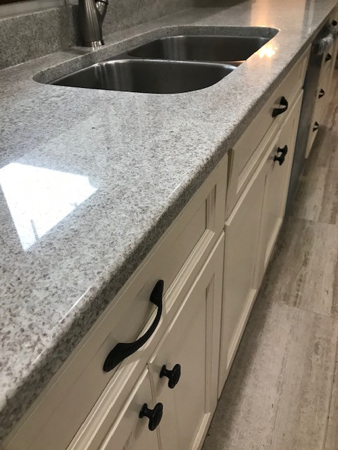 Mid-sized transitional galley porcelain tile and beige floor eat-in kitchen photo with an undermount sink, flat-panel cabinets, beige cabinets, granite countertops, multicolored backsplash, mosaic tile backsplash, stainless steel appliances, a peninsula and white countertops