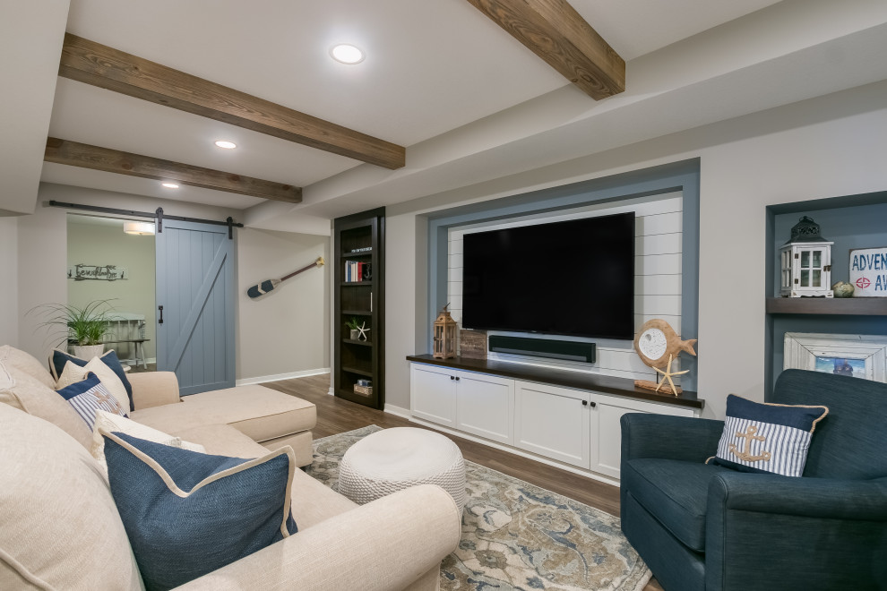 Large beach style open concept family room in Minneapolis with beige walls, light hardwood floors, a built-in media wall, brown floor and exposed beam.