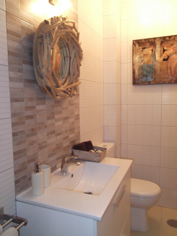 Photo of a mid-sized scandinavian powder room in Mexico City with flat-panel cabinets, white cabinets, a two-piece toilet, white walls and an integrated sink.