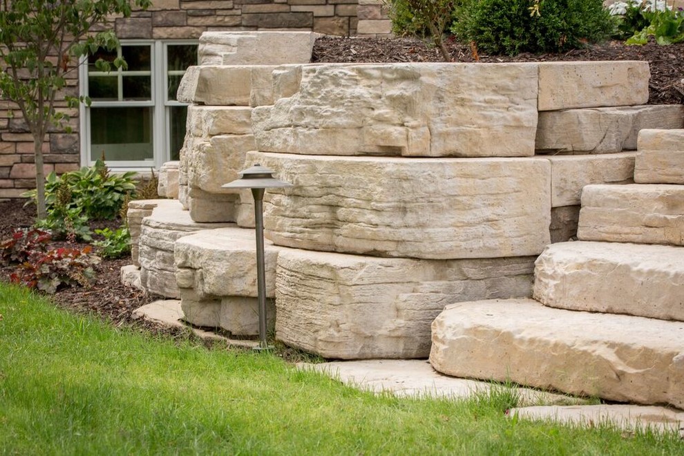 Inspiration for a mid-sized transitional full sun backyard stone landscaping in Chicago.
