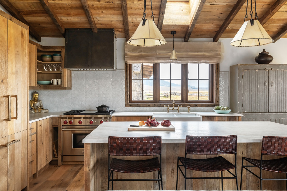 Design ideas for a country l-shaped kitchen in Other with a farmhouse sink, medium wood cabinets, white splashback, stainless steel appliances, medium hardwood floors, with island, white benchtop and flat-panel cabinets.