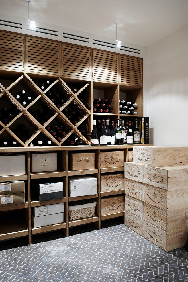 Photo of a large traditional wine cellar in Copenhagen with brick floors and diamond bins.