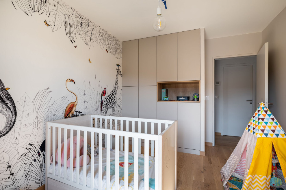 Idées déco pour une grande chambre de bébé fille moderne avec parquet clair et du papier peint.