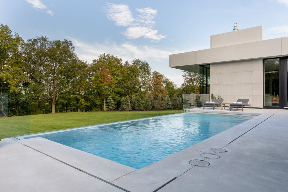 Kleiner Moderner Infinity-Pool hinter dem Haus in rechteckiger Form mit Sichtschutz und Betonplatten in Toronto