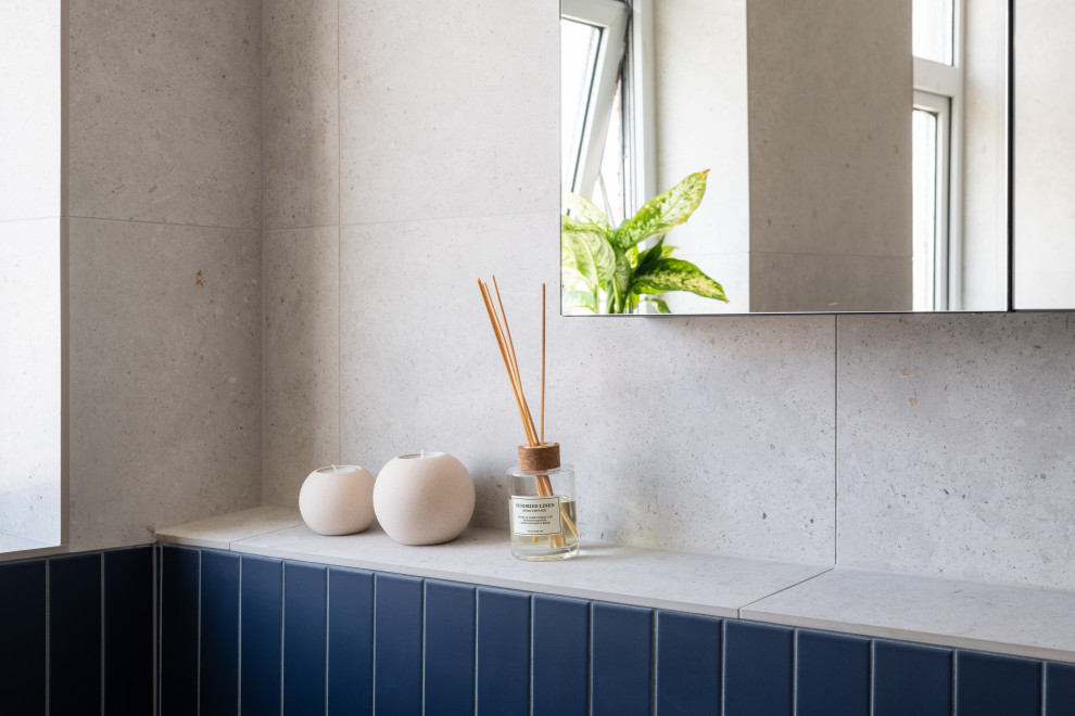 Photo of a medium sized contemporary family bathroom in London with a freestanding bath, a walk-in shower, a one-piece toilet, grey tiles, porcelain tiles, grey walls, porcelain flooring, a wall-mounted sink, concrete worktops, grey floors, a hinged door, orange worktops and a single sink.