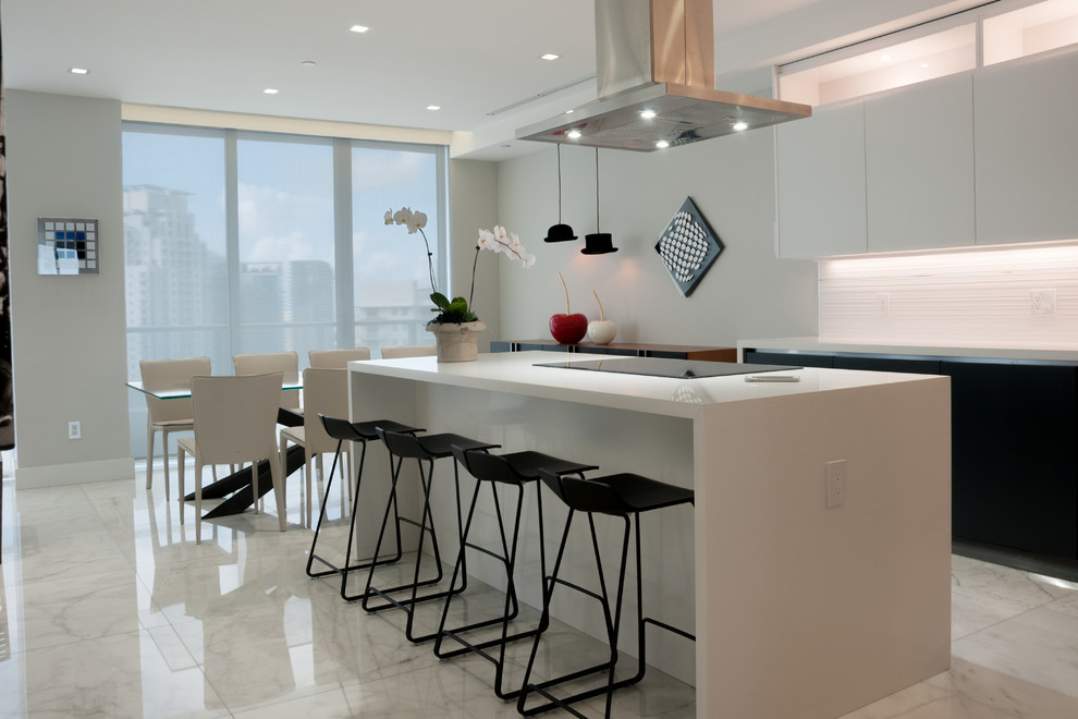 This is an example of a large modern l-shaped eat-in kitchen in Miami with an undermount sink, glass-front cabinets, grey cabinets, quartzite benchtops, white splashback, slate splashback, stainless steel appliances, marble floors, with island and white floor.