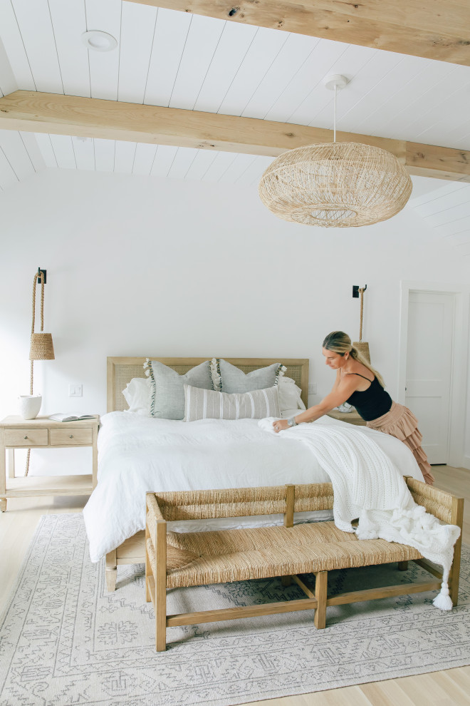 Large beach style master bedroom in Other with white walls, light hardwood floors, no fireplace, brown floor, exposed beam and planked wall panelling.