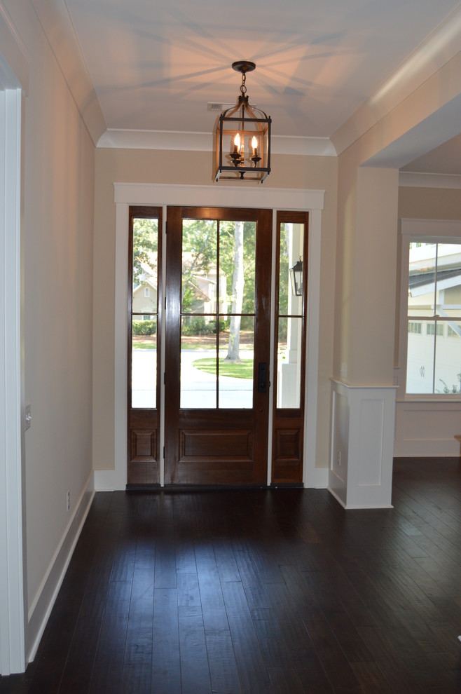 Photo of an arts and crafts foyer in Charleston with beige walls, dark hardwood floors, a single front door, a brown front door and brown floor.