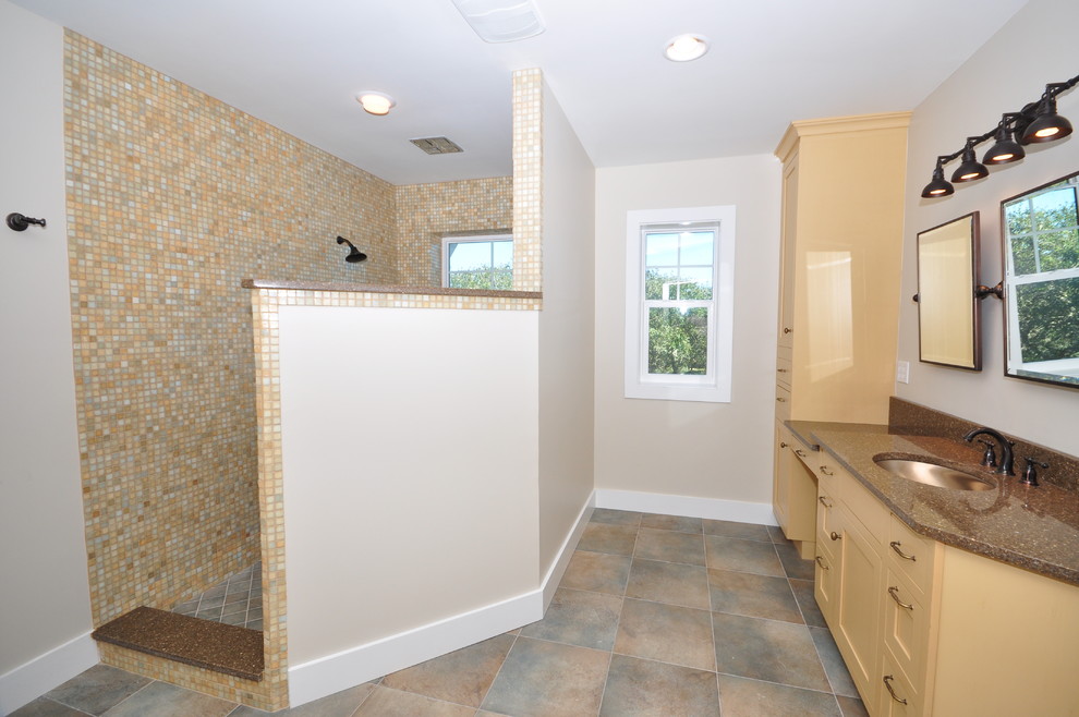 This is an example of a beach style bathroom in Jacksonville with an undermount sink, recessed-panel cabinets, beige cabinets, an open shower, multi-coloured tile, ceramic tile and beige walls.