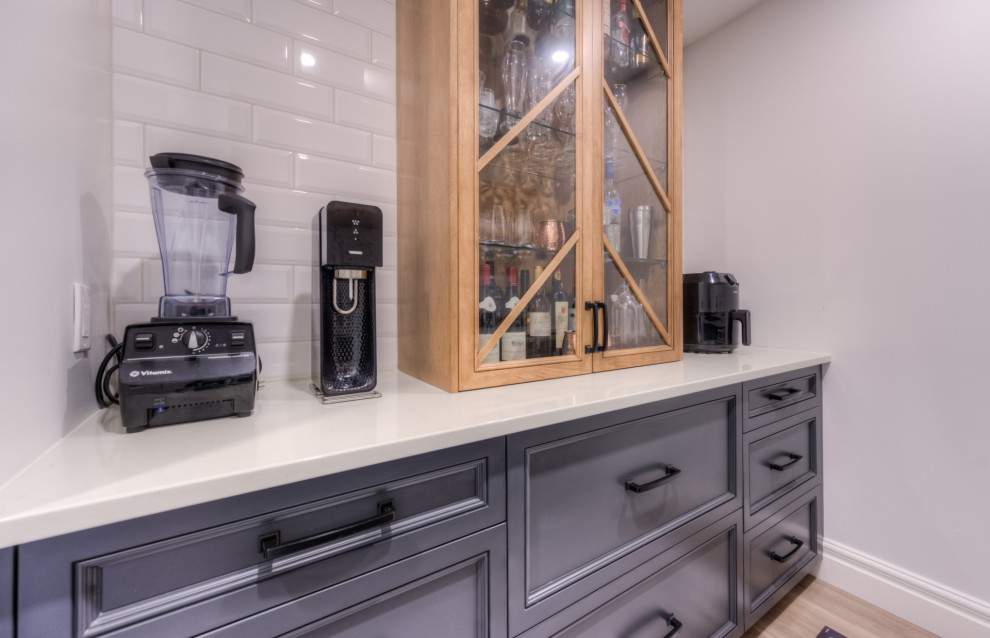 Example of a transitional galley kitchen design in Toronto with shaker cabinets, white backsplash and white countertops