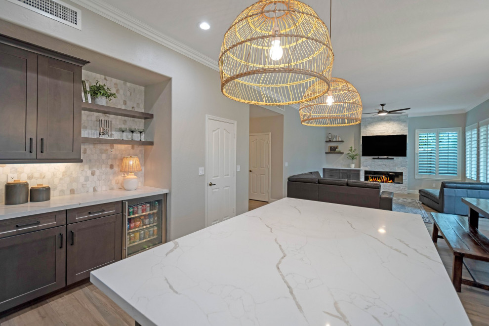 Example of a large porcelain tile and brown floor eat-in kitchen design in Phoenix with an undermount sink, shaker cabinets, quartz countertops, multicolored backsplash, marble backsplash, stainless steel appliances, an island and white countertops