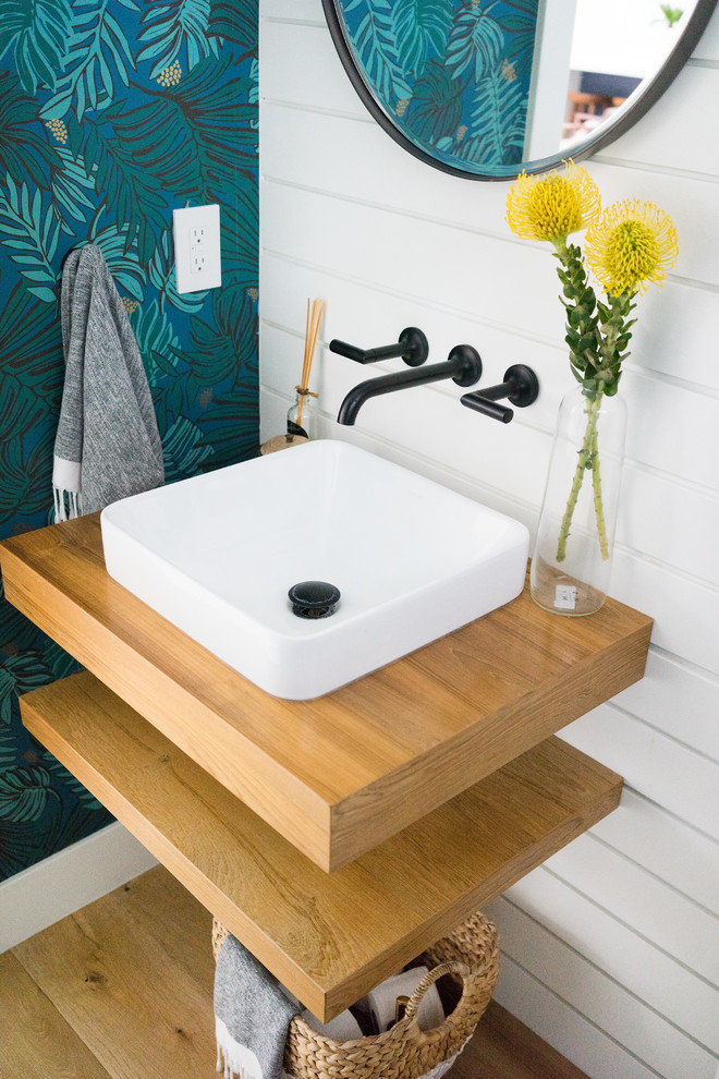 Inspiration for a mid-sized midcentury powder room in Orange County with light wood cabinets, white walls, light hardwood floors, a vessel sink and wood benchtops.