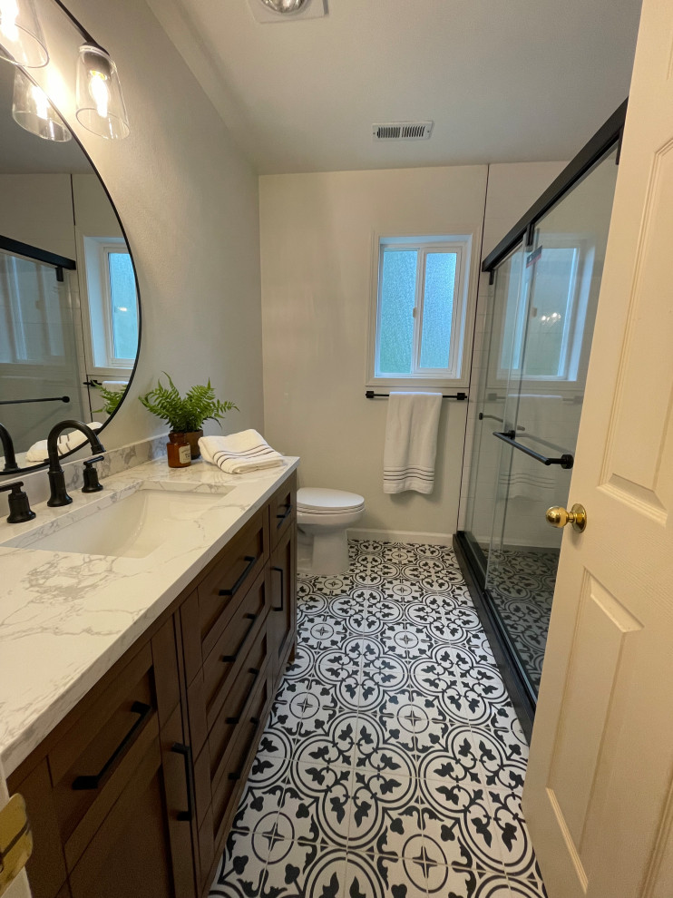 Mid-sized farmhouse 3/4 white tile and porcelain tile mosaic tile floor, black floor and single-sink bathroom photo in Seattle with shaker cabinets, medium tone wood cabinets, a one-piece toilet, white walls, an undermount sink and a freestanding vanity