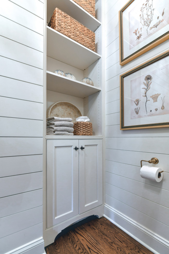 Inspiration for a small traditional bathroom in Charleston with beaded inset cabinets, white cabinets, medium hardwood floors, an undermount sink, brown floor, a built-in vanity and planked wall panelling.