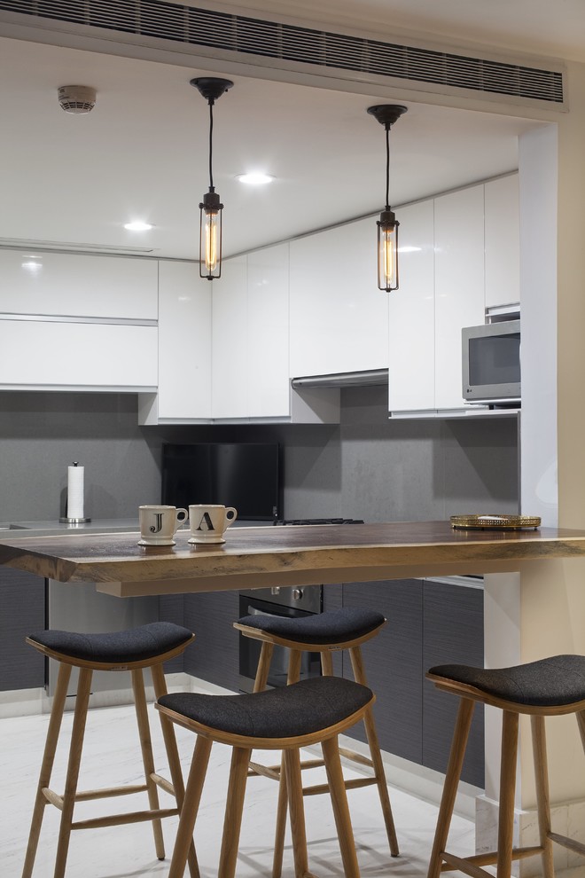 This is an example of a small modern u-shaped eat-in kitchen in Other with a drop-in sink, louvered cabinets, white cabinets, onyx benchtops, grey splashback, stainless steel appliances, marble floors and with island.