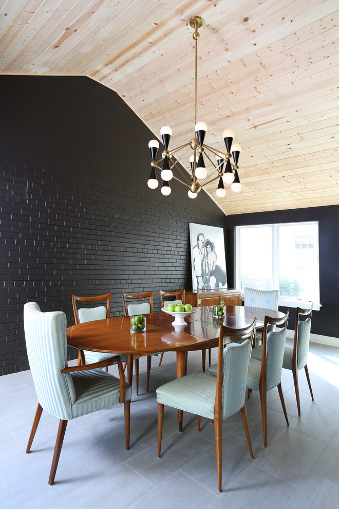 This is an example of a mid-sized midcentury dining room in Chicago with black walls, porcelain floors and no fireplace.