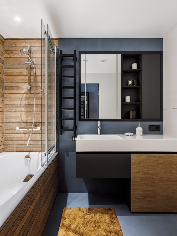 Idées déco pour une salle de bain principale contemporaine en bois brun de taille moyenne avec un placard à porte plane, une baignoire encastrée, un combiné douche/baignoire, un carrelage bleu, des carreaux de céramique, un mur marron, un sol en carrelage de céramique, un lavabo posé, un plan de toilette en surface solide, un sol bleu, une cabine de douche à porte coulissante, un plan de toilette blanc, meuble simple vasque et meuble-lavabo sur pied.
