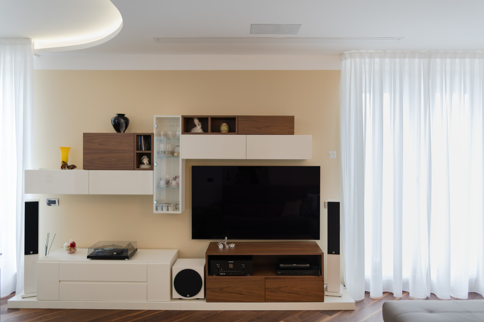 Photo of a mid-sized contemporary open concept living room in Milan with a library, beige walls, dark hardwood floors, a built-in media wall and brown floor.