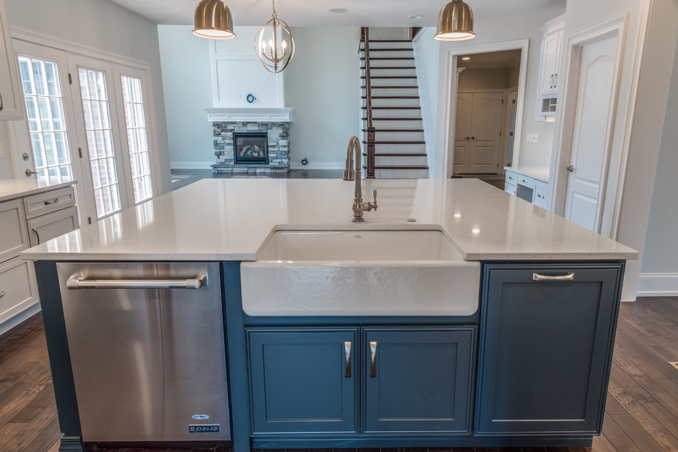 Inspiration for a large transitional u-shaped dark wood floor and brown floor kitchen remodel with a farmhouse sink, shaker cabinets, blue cabinets, quartzite countertops, stainless steel appliances and an island