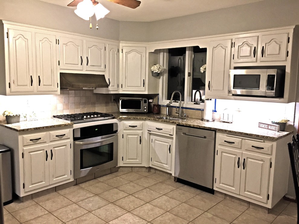 Mid-sized country eat-in kitchen in Philadelphia with an undermount sink, white cabinets, granite benchtops, beige splashback, stone tile splashback, stainless steel appliances and no island.