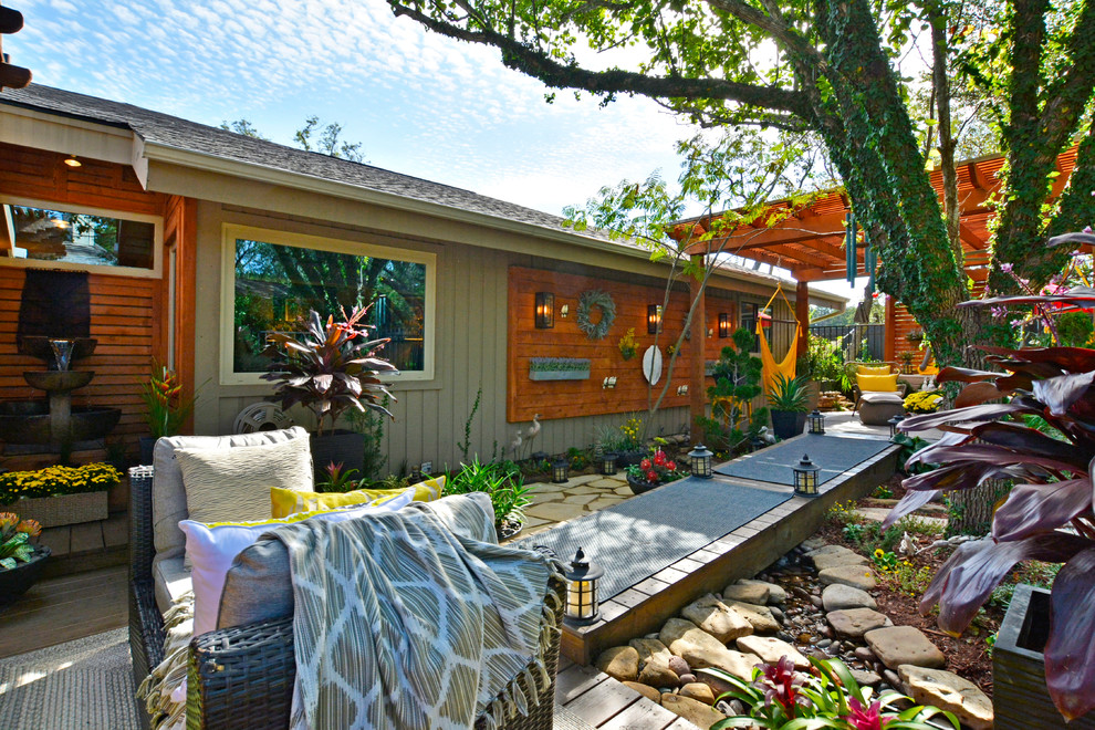 This is an example of a large eclectic backyard deck in Austin with a container garden and a pergola.