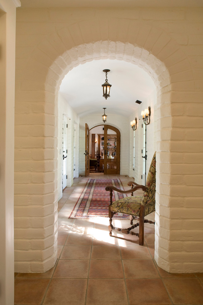 Mid-sized mediterranean hallway in Santa Barbara with white walls and terra-cotta floors.