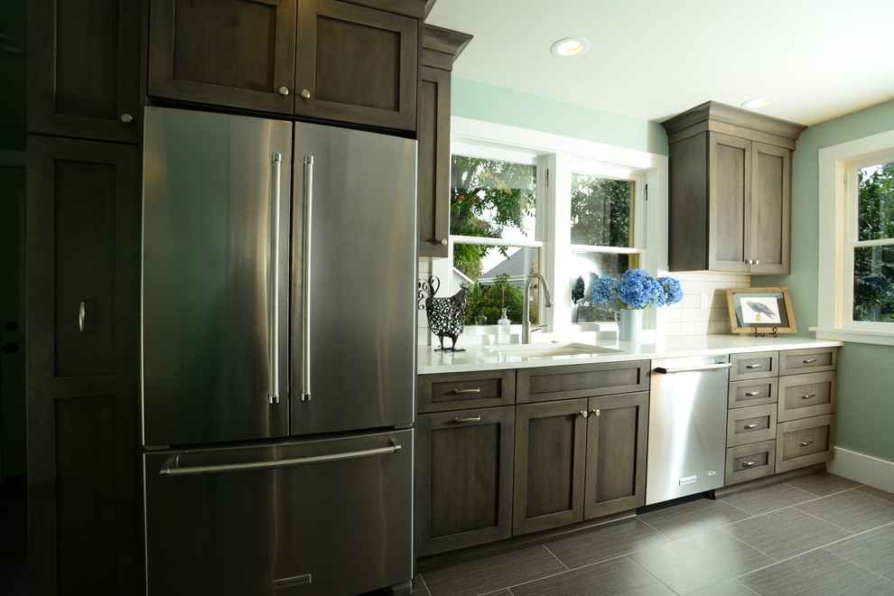Inspiration for a mid-sized transitional galley vinyl floor eat-in kitchen remodel in Seattle with an undermount sink, shaker cabinets, medium tone wood cabinets, quartz countertops, white backsplash, ceramic backsplash, stainless steel appliances and no island