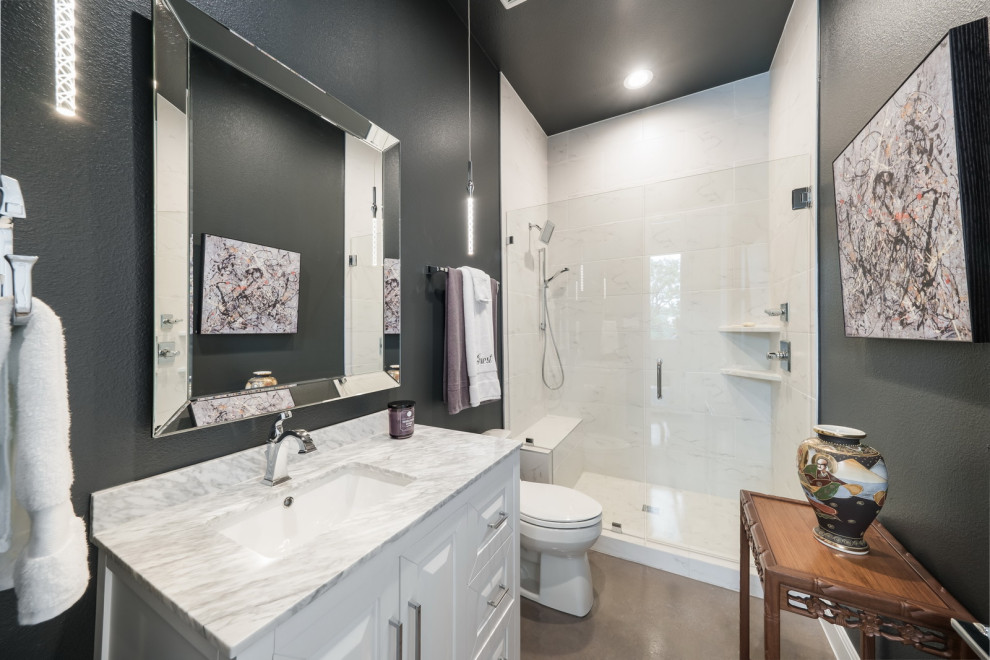 Mid-sized tuscan concrete floor, gray floor and single-sink bathroom photo in Other with furniture-like cabinets, gray cabinets, a one-piece toilet, green walls, an undermount sink, marble countertops and white countertops