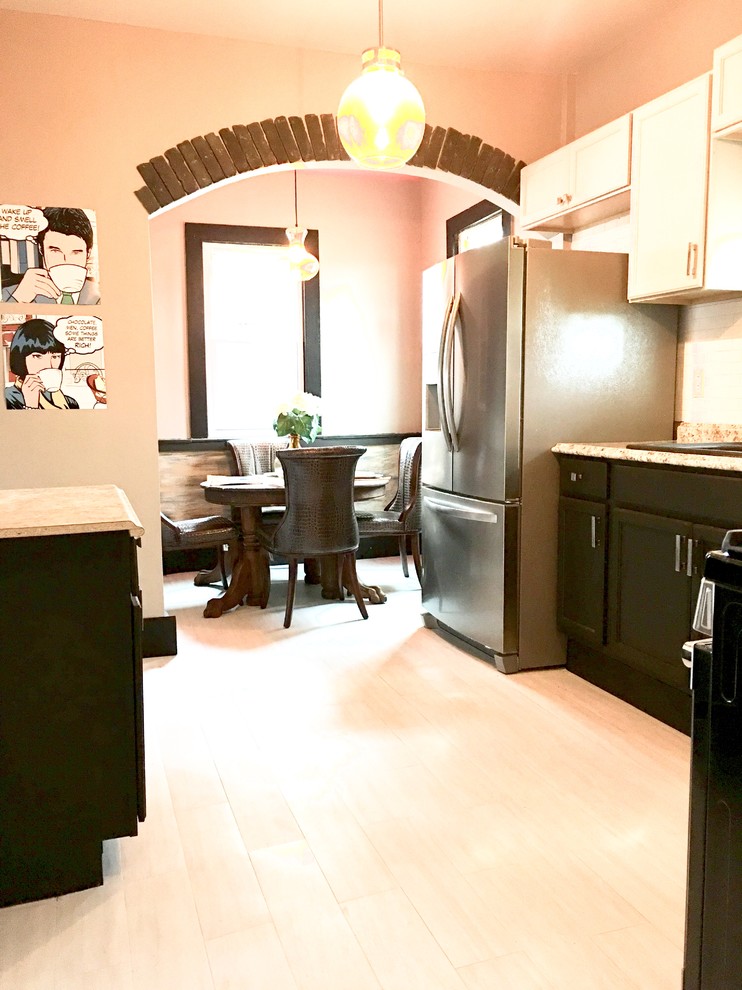 Example of a mid-sized transitional l-shaped vinyl floor and white floor enclosed kitchen design with a double-bowl sink, recessed-panel cabinets, black cabinets, laminate countertops, white backsplash, subway tile backsplash, stainless steel appliances and gray countertops