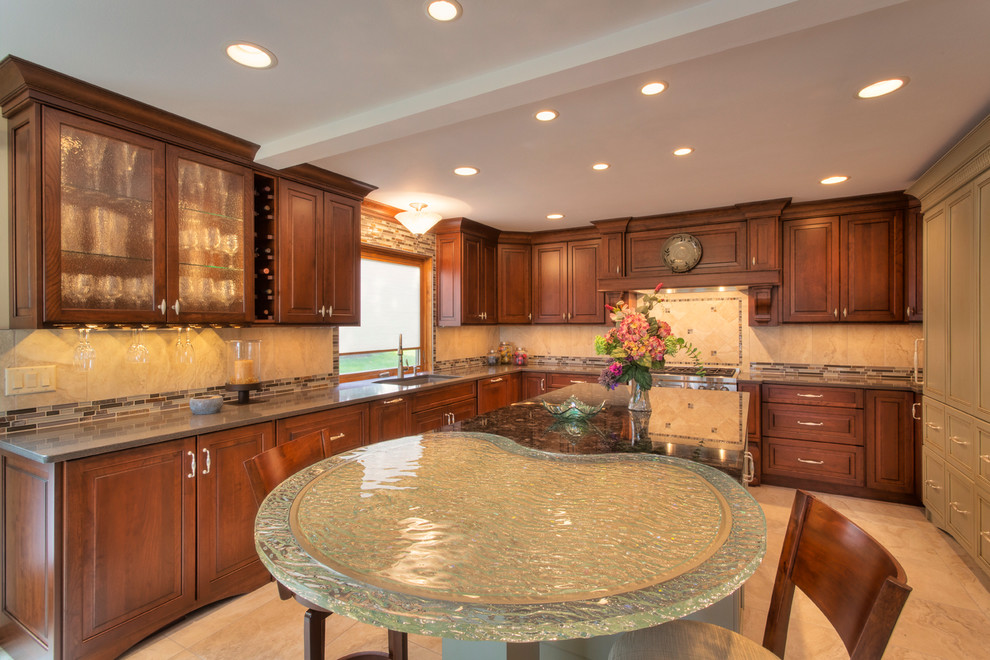 Example of a large transitional l-shaped ceramic tile eat-in kitchen design with an undermount sink, raised-panel cabinets, medium tone wood cabinets, glass countertops, multicolored backsplash, mosaic tile backsplash, paneled appliances and an island