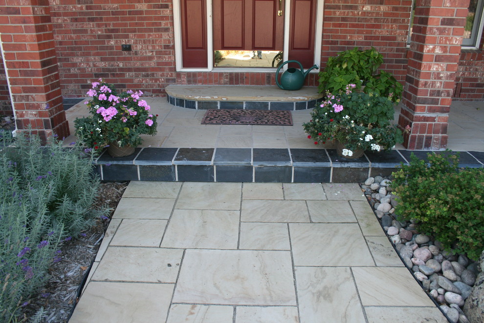 Design ideas for a small traditional front yard partial sun driveway in Denver with natural stone pavers.