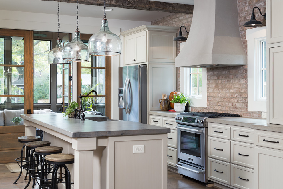 Inspiration for a mid-sized country galley open plan kitchen in Birmingham with a farmhouse sink, shaker cabinets, white cabinets, concrete benchtops, red splashback, stainless steel appliances, medium hardwood floors and with island.