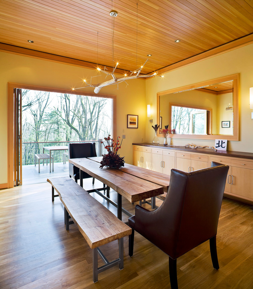 Design ideas for a traditional dining room in Portland with yellow walls and dark hardwood floors.