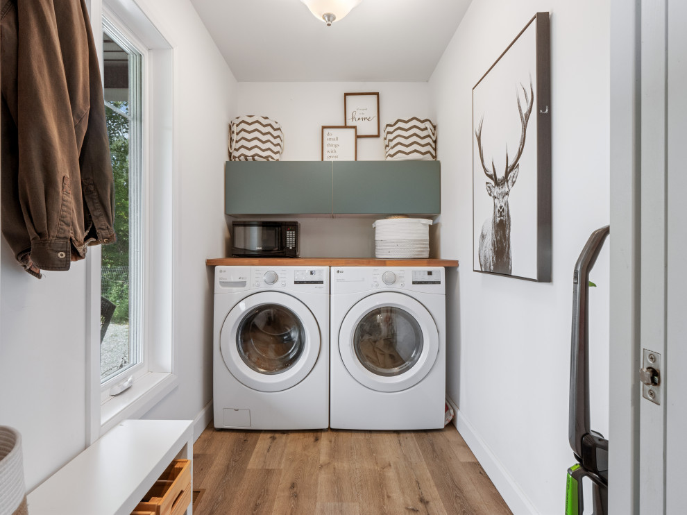 Imagen de cuarto de lavado de galera rural pequeño con armarios con paneles lisos, paredes blancas y lavadora y secadora juntas