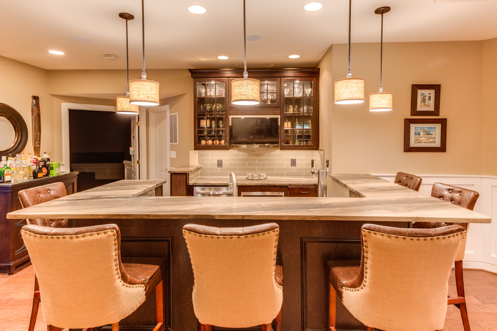 This is an example of a mid-sized traditional u-shaped wet bar in DC Metro with raised-panel cabinets, granite benchtops, glass tile splashback and medium hardwood floors.
