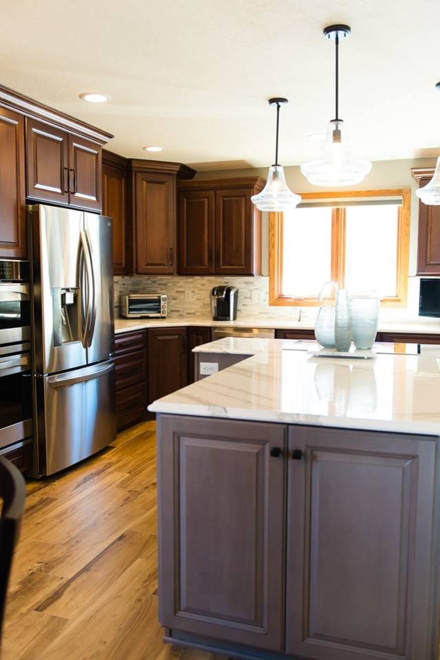Inspiration for a transitional ceramic tile and brown floor eat-in kitchen remodel with brown cabinets, quartzite countertops, beige backsplash, ceramic backsplash, stainless steel appliances, an island and white countertops