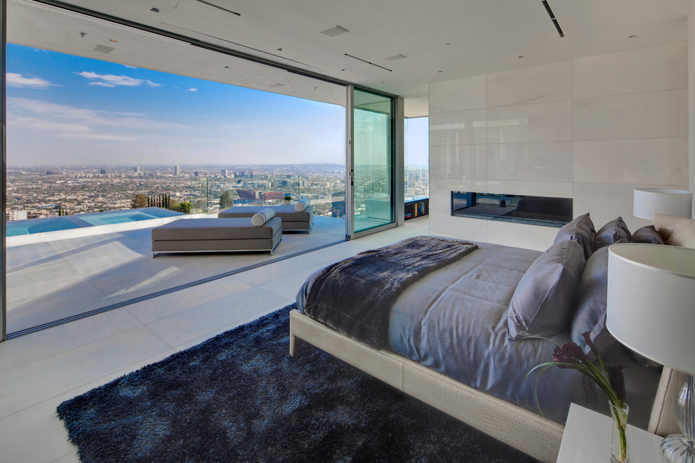 Example of a trendy bedroom design in Los Angeles with white walls, a ribbon fireplace and a tile fireplace