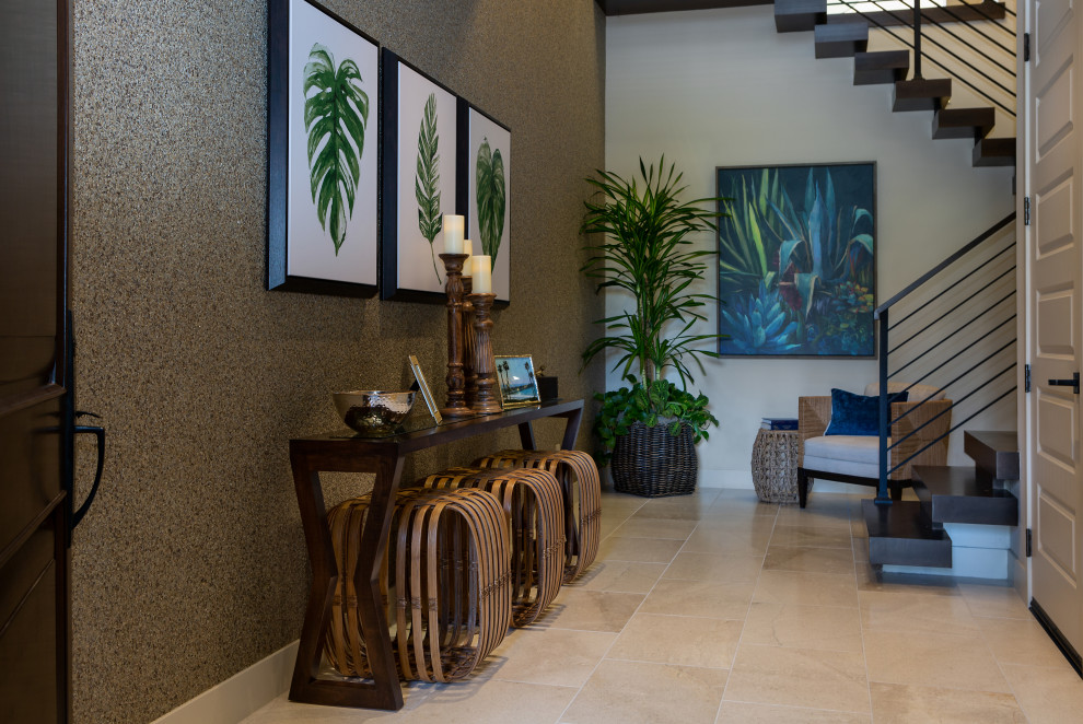 Photo of a tropical entryway in Orange County with limestone floors, beige floor and wallpaper.