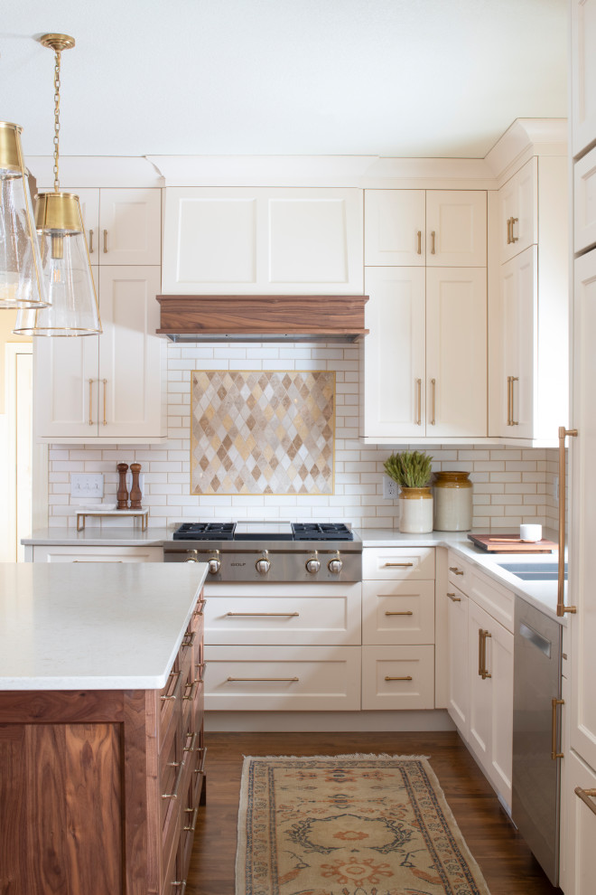 Inspiration for a mid-sized transitional l-shaped eat-in kitchen in Minneapolis with an undermount sink, shaker cabinets, quartz benchtops, with island, white cabinets, white splashback, subway tile splashback, stainless steel appliances, medium hardwood floors, brown floor and white benchtop.