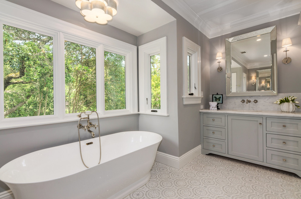 Inspiration for a large traditional master bathroom with grey cabinets, a freestanding tub, a corner shower, a two-piece toilet, white tile, marble, grey walls, mosaic tile floors, an undermount sink, marble benchtops, grey floor, a hinged shower door, white benchtops and shaker cabinets.