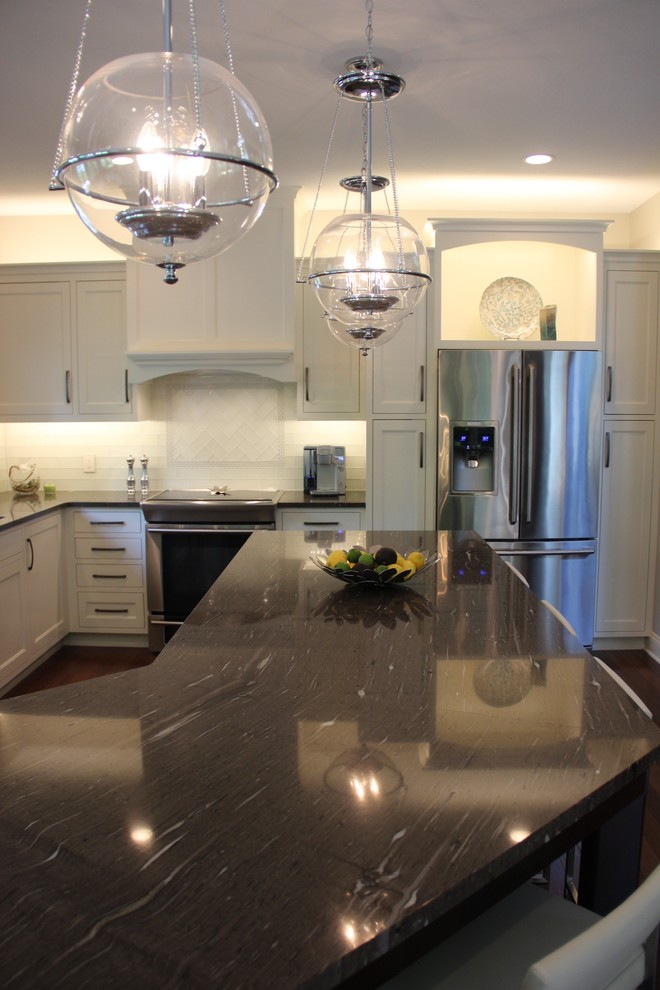 Eat-in kitchen - mid-sized transitional l-shaped dark wood floor eat-in kitchen idea with a double-bowl sink, shaker cabinets, white cabinets, granite countertops, white backsplash, glass tile backsplash, stainless steel appliances and an island