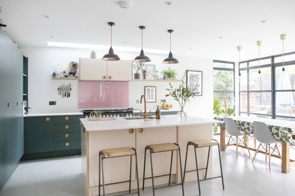 Photo of a small contemporary single-wall open plan kitchen in London with an undermount sink, beaded inset cabinets, blue cabinets, quartzite benchtops, pink splashback, ceramic splashback, black appliances, ceramic floors, with island, grey floor, white benchtop and coffered.