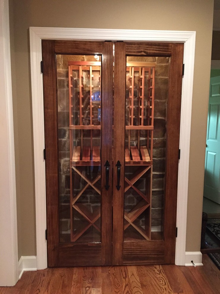 Small traditional wine cellar in Atlanta with medium hardwood floors, storage racks and brown floor.