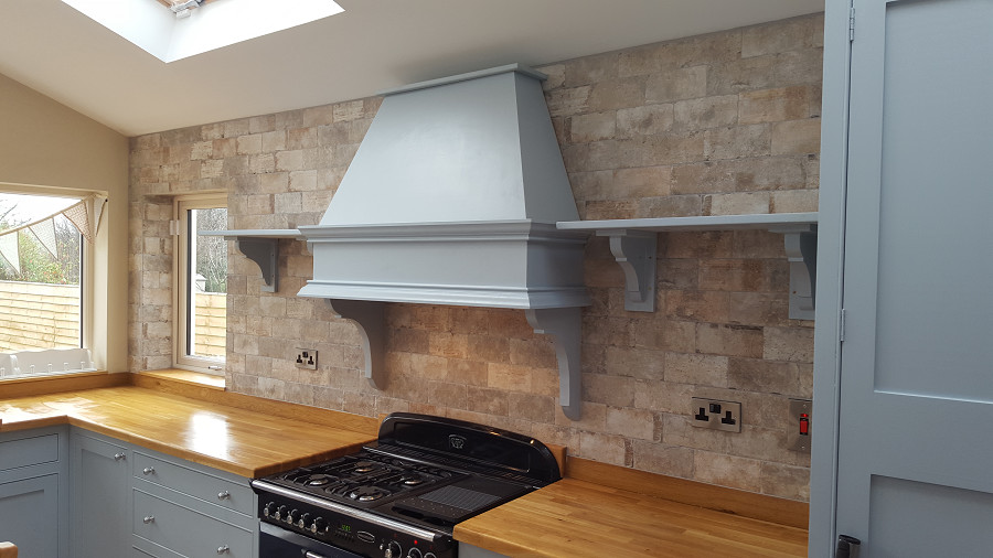 Inspiration for a rustic eat-in kitchen remodel in Dublin with blue cabinets, wood countertops and subway tile backsplash