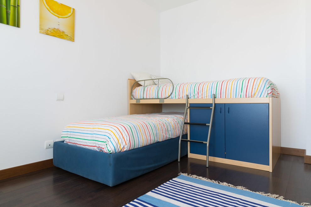 This is an example of a mid-sized scandinavian gender-neutral kids' bedroom for kids 4-10 years old in Other with white walls and dark hardwood floors.