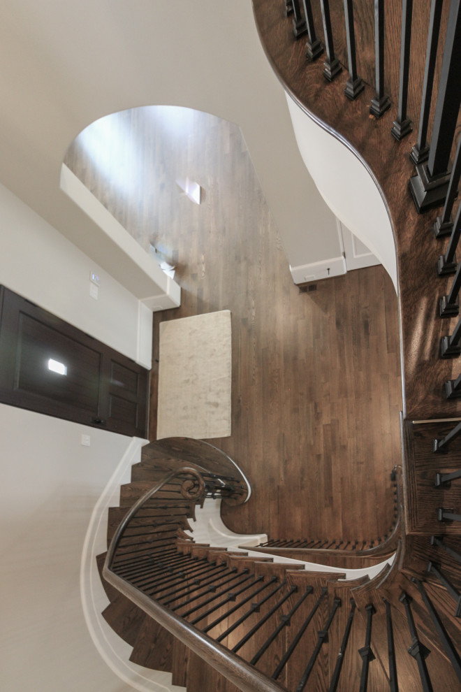 Cette image montre un grand escalier peint flottant traditionnel avec des marches en bois et un garde-corps en métal.