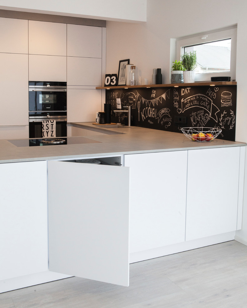 Источник вдохновения для домашнего уюта: кухня-гостиная среднего размера в скандинавском стиле с монолитной мойкой, белыми фасадами, столешницей из бетона и техникой из нержавеющей стали