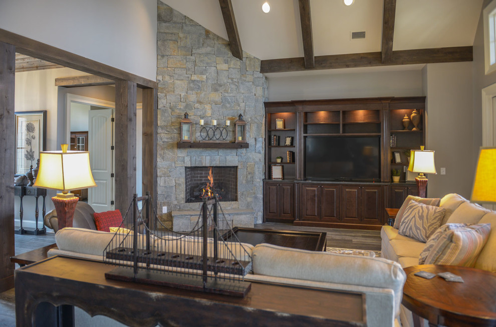 Inspiration for a mid-sized rustic formal and open concept dark wood floor living room remodel with gray walls, a corner fireplace, a stone fireplace and a media wall