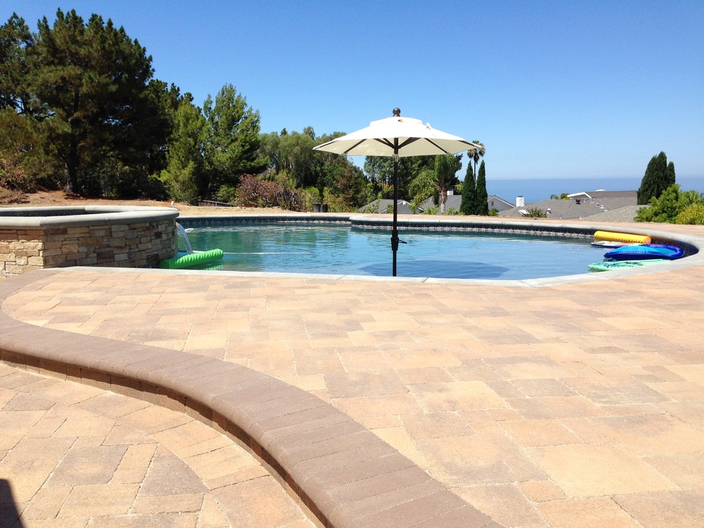 Inspiration for a large contemporary backyard custom-shaped lap pool in Orange County with a hot tub and tile.