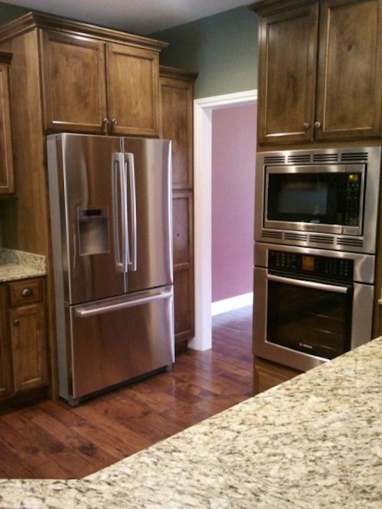 Eat-in kitchen - large galley eat-in kitchen idea with a drop-in sink, beaded inset cabinets, medium tone wood cabinets, beige backsplash, stainless steel appliances and an island